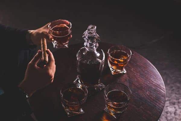 Man met luxe whiskey glas en sigaar